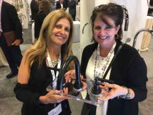 immerse employees holding up rohl bathroom faucet at the bathroom showroom gallery