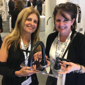 immerse employees holding up rohl bathroom faucet at the bathroom showroom gallery