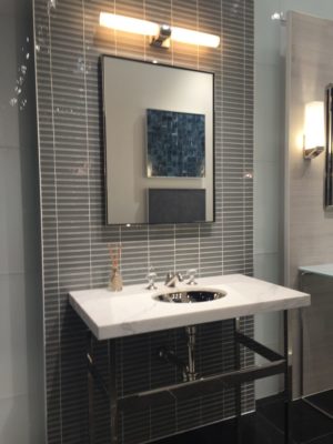 lighted luxury mirror, bathroom faucet and sink on display at the immerse showroom in st. louis
