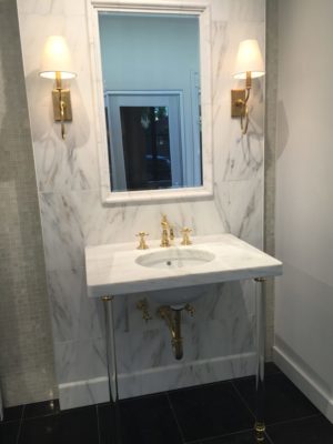marble vanity top, sink, faucet, and mirror on display at the immerse showroom in st. louis