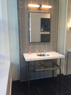 lighted mirror, vanity, faucet and sink on display at the immerse showroom in st. louis