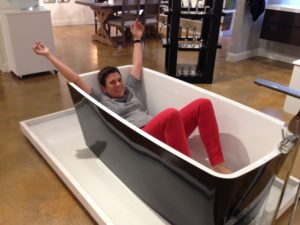 immerse employee in freestanding tub on display at the immerse showroom in st. louis