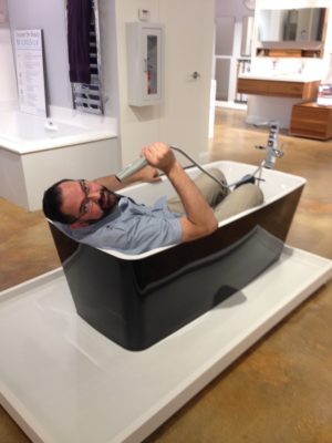 immerse employee in freestanding tub on display at the immerse showroom in st. louis