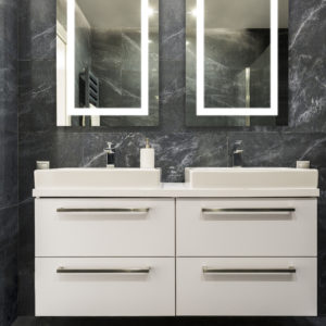 dark granite bathroom and lighted mirrors on display at the immerse showroom