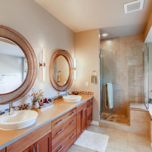 designer master bathroom with tub, shower, mirrors, lighting, and vanity