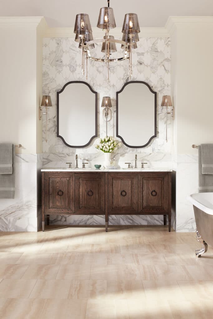 Two unique bathroom mirrors on a faux marble slab with a dark wood grain bathroom vanity.